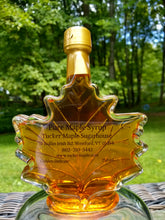 Load image into Gallery viewer, Maple leaf shaped glass bottle filled with maple syrup made by Tucker Maple Sugarhouse